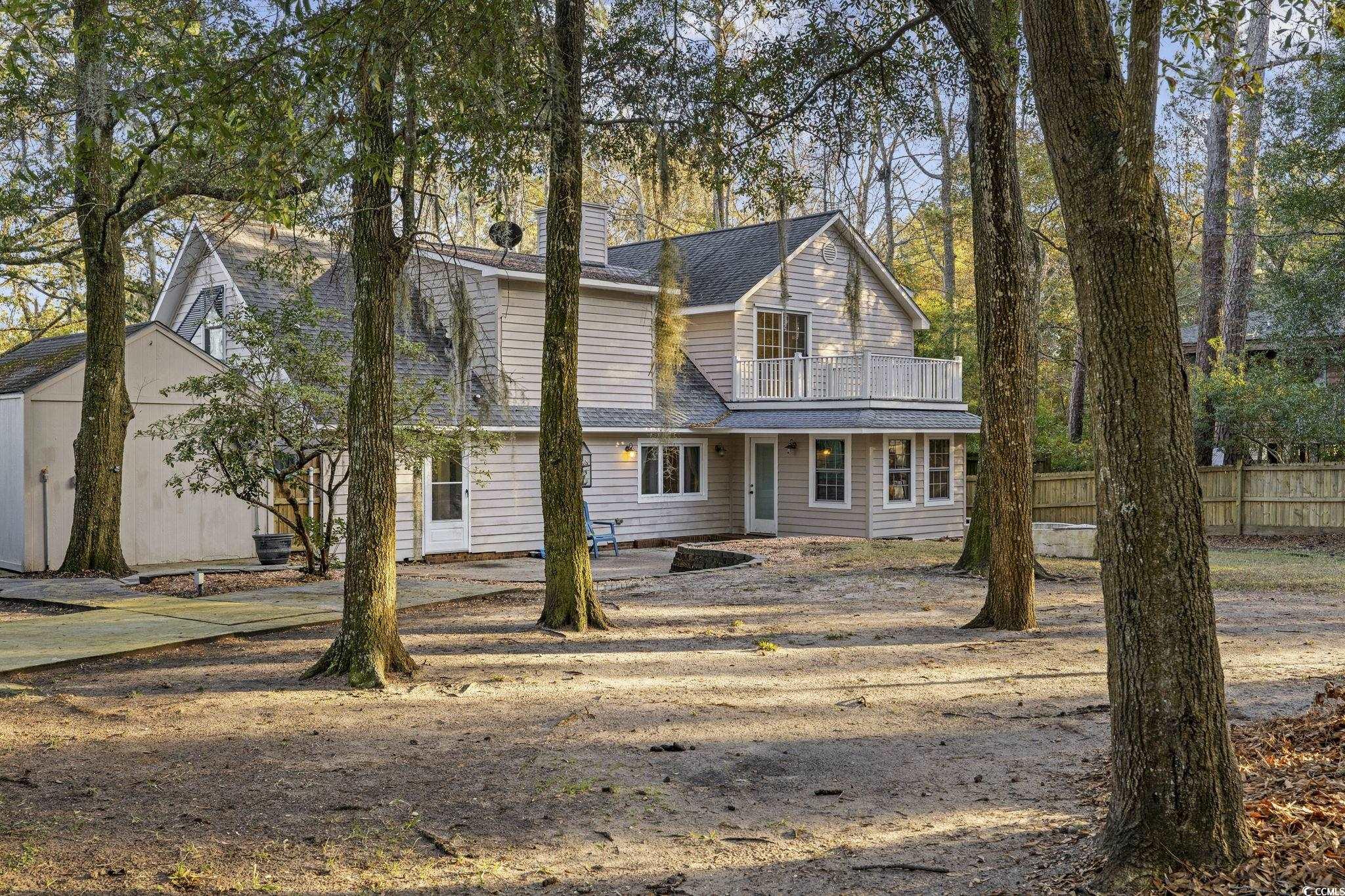 153 Watson Way Pawleys Island, SC 29585 - Photo 29 of 40 View of front facade featuring a chimney, a patio area, a balcony, and roof with shingles