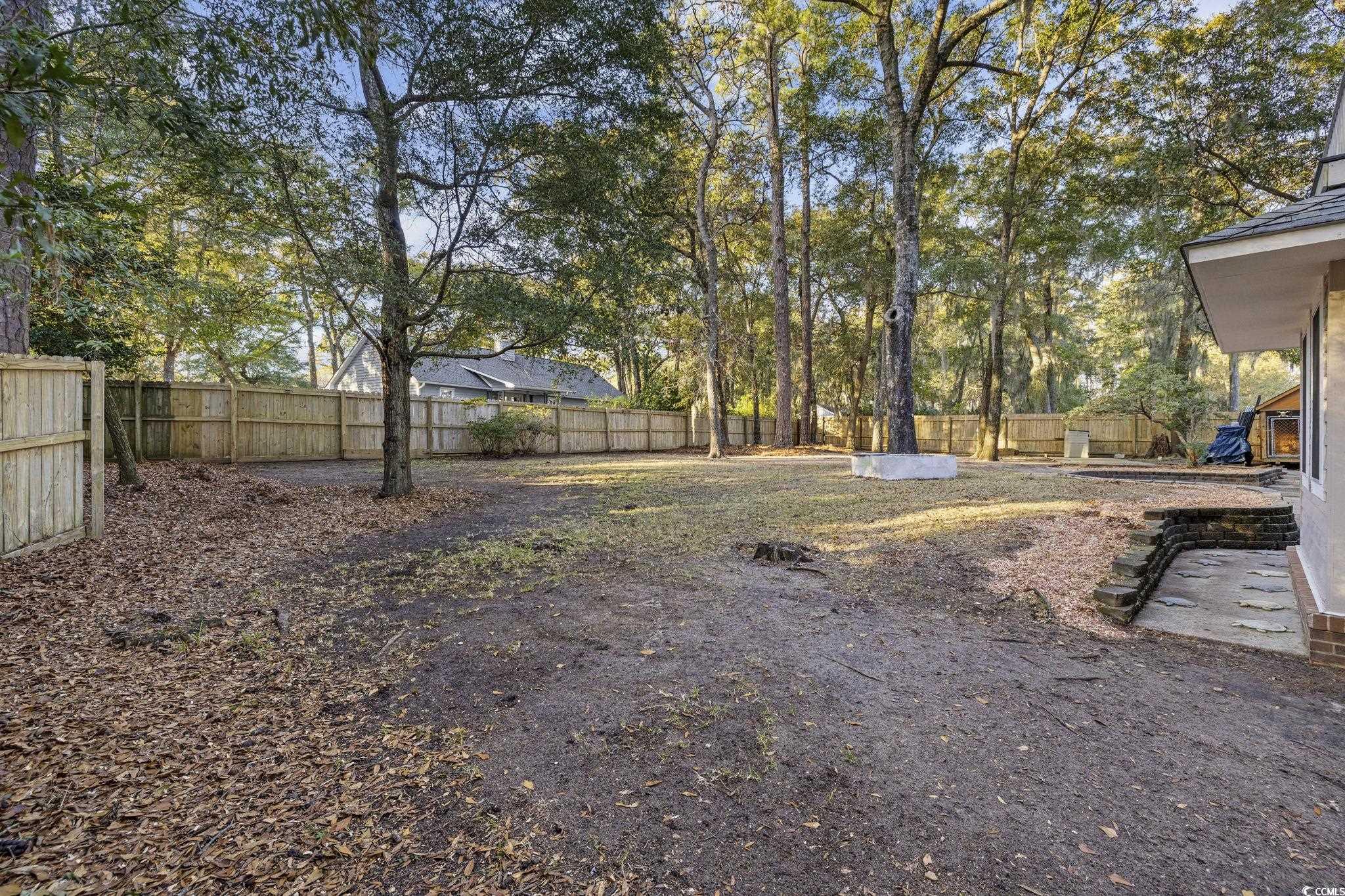 153 Watson Way Pawleys Island, SC 29585 - Photo 31 of 40 Fenced backyard with a patio area