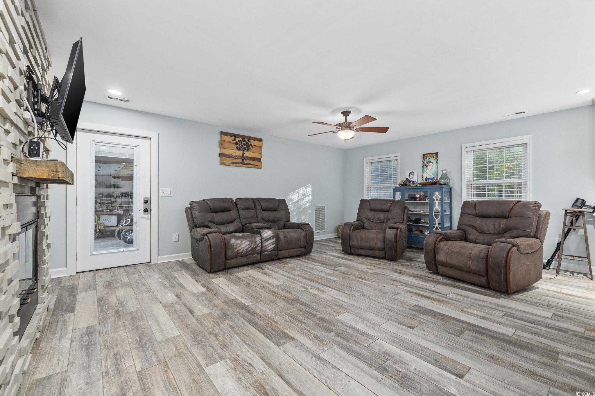 153 Watson Way Pawleys Island, SC 29585 - Photo 8 of 40 Living area featuring recessed lighting, a ceiling fan, a stone fireplace, and light wood-type flooring