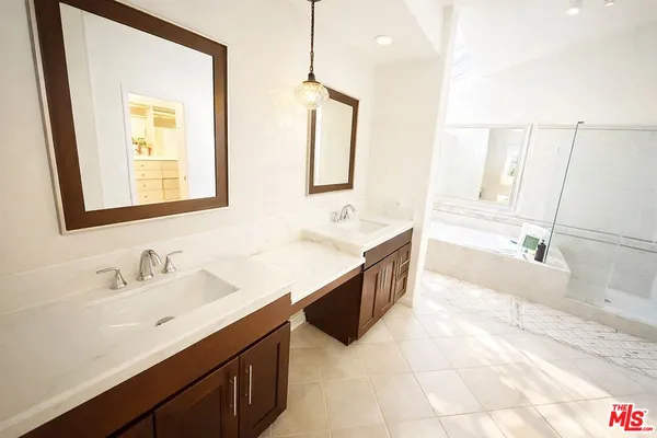 a bathroom with a double vanity sink a mirror and a bathtub