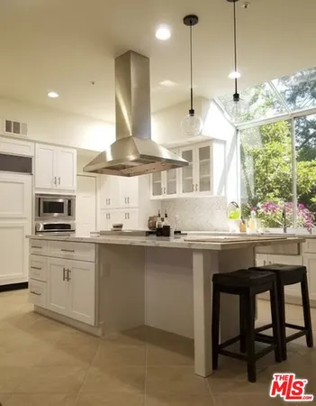 a kitchen with kitchen island granite countertop a sink window and stainless steel appliances