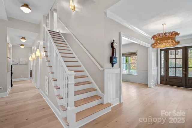 a view of a hallway with wooden floor and stairs