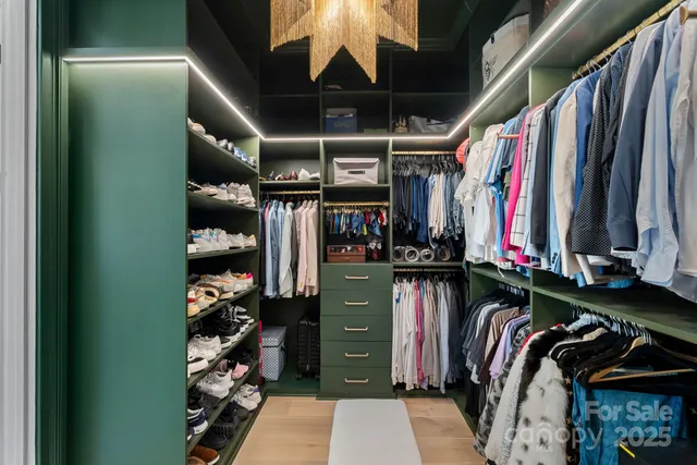 a view of walk in closet with clothes and shoes