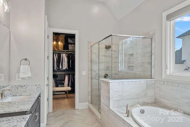 a bathroom with a granite countertop bathtub shower sink and toilet