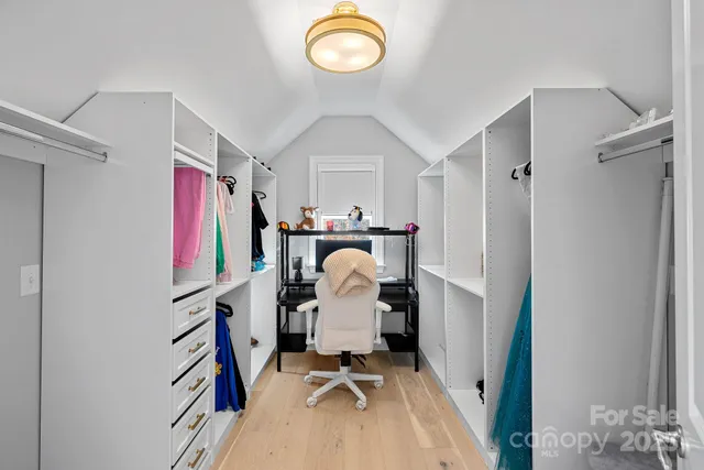 a view of walk in closet with clothes and shoes
