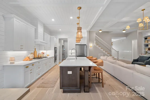 a large kitchen with kitchen island a island a stove a sink a dining table and chairs