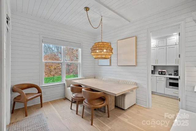 a kitchen with a table chairs a sink dishwasher window and cabinets
