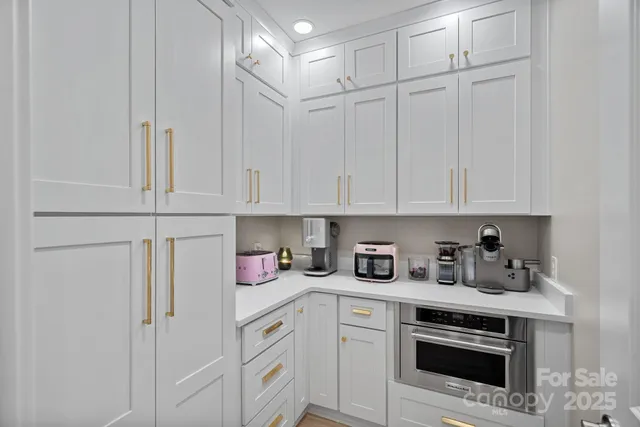 a kitchen with stainless steel appliances white cabinets and white appliances