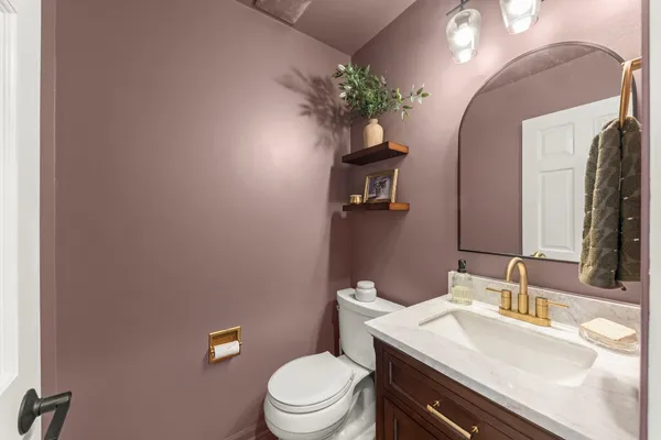 a bathroom with a toilet a sink and mirror