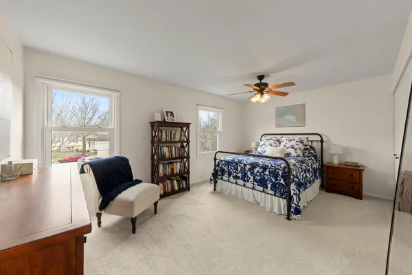 a bedroom with bed chair and window