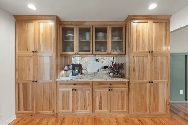 a kitchen with white cabinets and a window