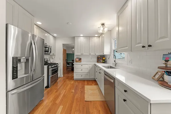a kitchen with white cabinets and stainless steel appliances