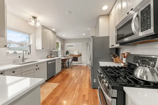 a kitchen with stainless steel appliances a stove a sink and a microwave