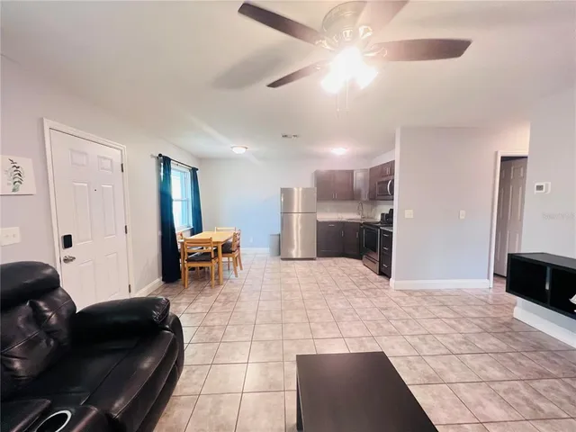 a living room with furniture and a dining table with kitchen view