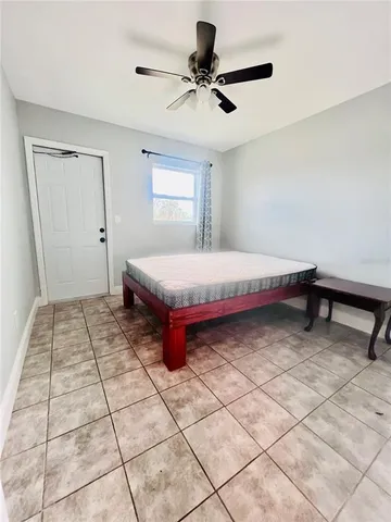 a room with a bed and a ceiling fan