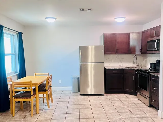 a kitchen with a refrigerator and a stove top oven