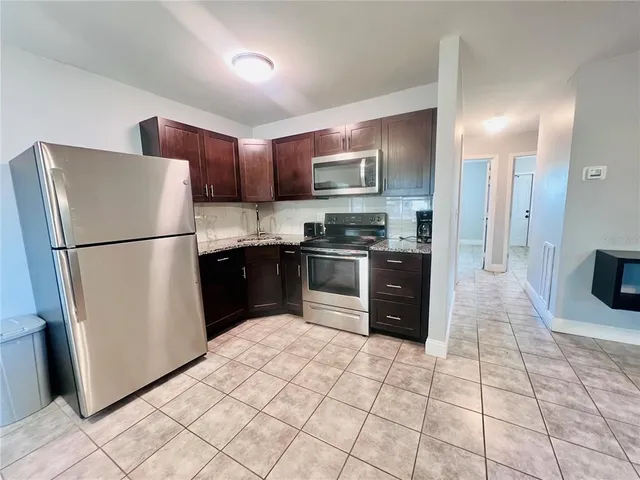 a kitchen with stainless steel appliances granite countertop a refrigerator and a sink