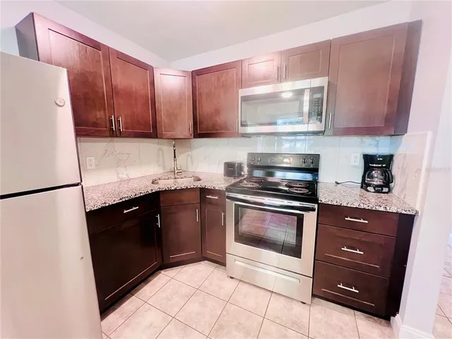 a kitchen with a refrigerator sink and cabinets