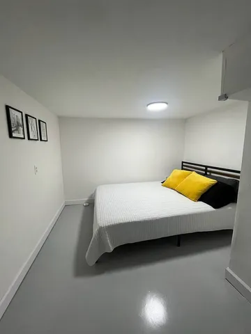 a bedroom with a bed and painting on the wall