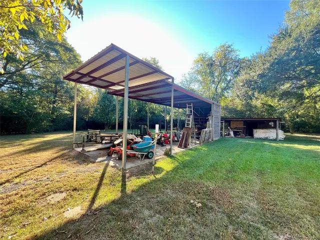a view of a backyard with table and chairs under an umbrella