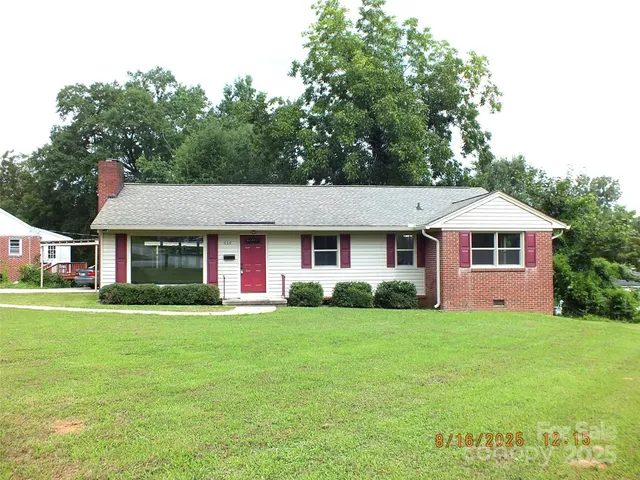 a front view of a house with a yard and trees