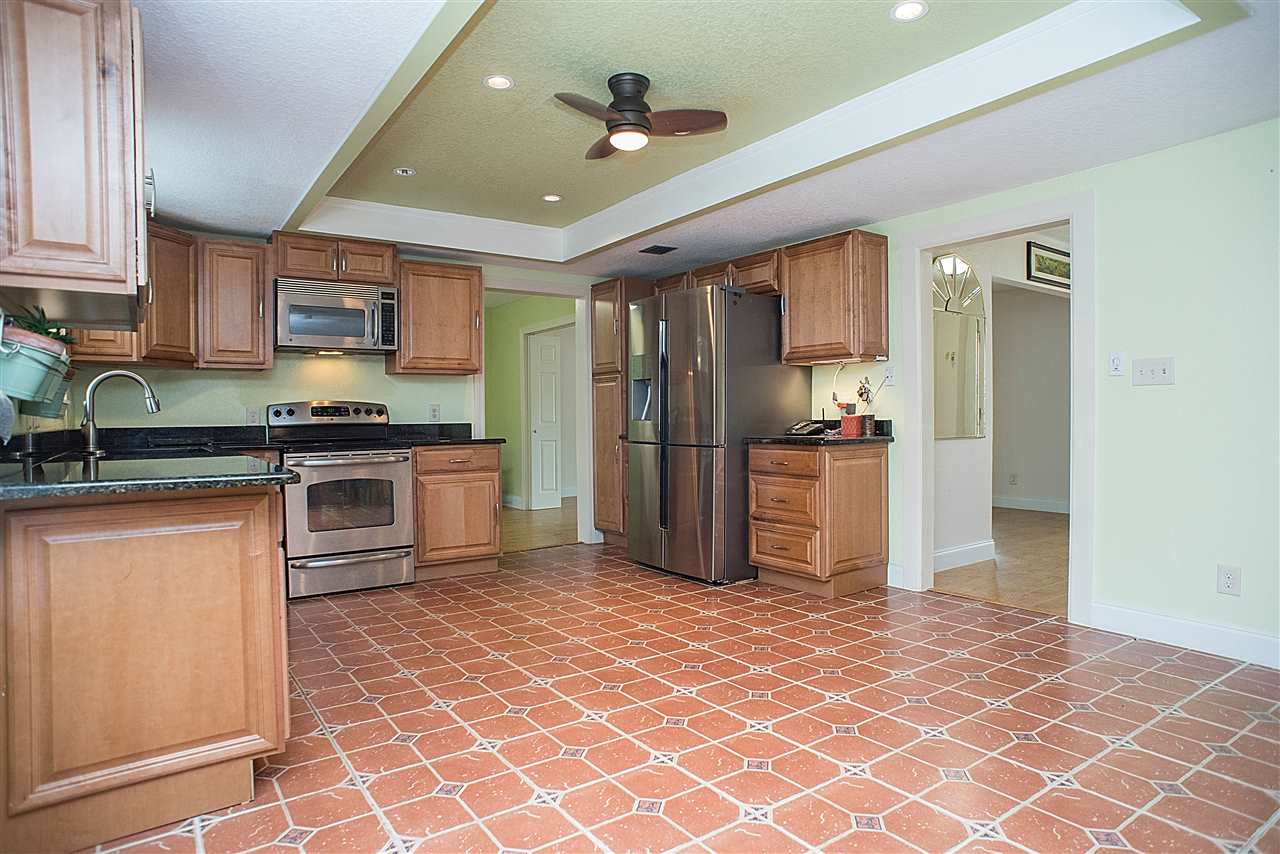 503 Royal Road St. Augustine, FL 32086 - Photo 8 of 34 a kitchen with stainless steel appliances granite countertop a refrigerator a sink dishwasher a stove with wooden cabinets and floor