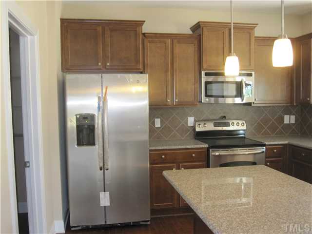 7608 Birchmoor Way, Unit LT75 Raleigh, NC 27616 - Photo 3 of 12 a kitchen with kitchen island granite countertop cabinets and stainless steel appliances