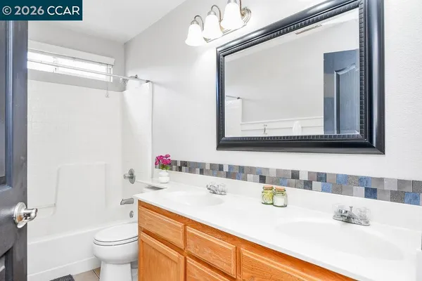 a bathroom with a sink vanity mirror and toilet