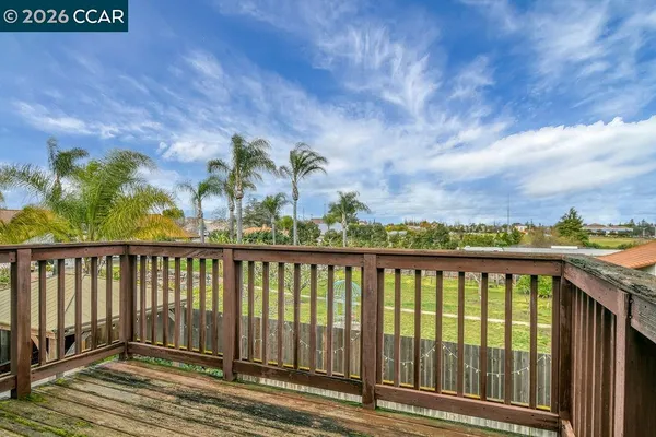 a view of a balcony with wooden floor and fence