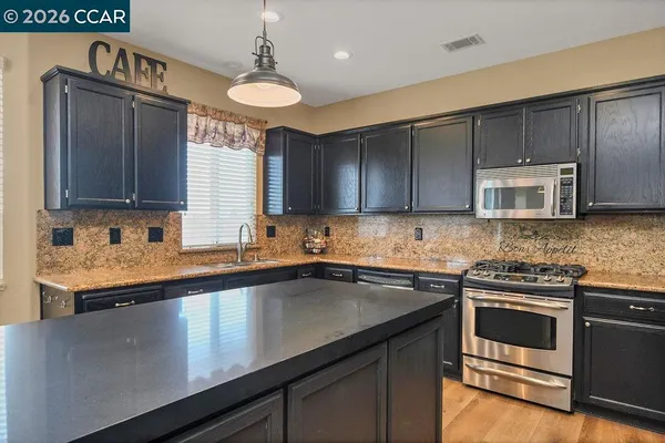 a kitchen with stainless steel appliances a sink stove and microwave