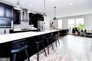 a kitchen with stainless steel appliances kitchen island granite countertop stools a sink a counter space and cabinets