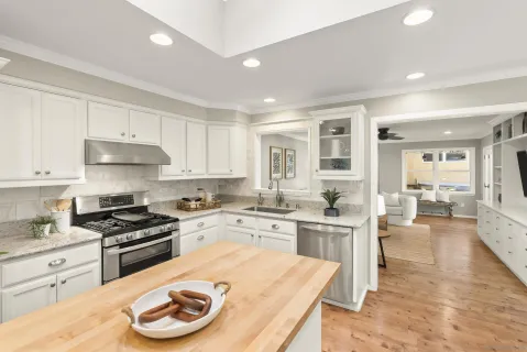 a kitchen with a stove a sink a dining table and chairs
