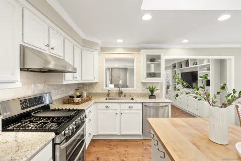 a large kitchen with stainless steel appliances granite countertop a lot of counter space and a sink