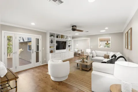 a living room with furniture a flat screen tv and a window