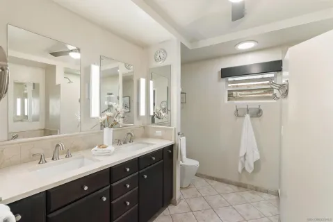 a bathroom with a double vanity sink a toilet and a mirror