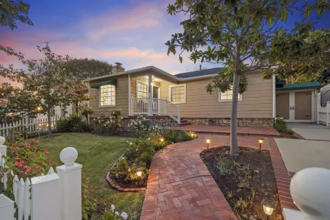 a front view of a house with a yard and a garden