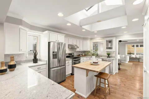 a kitchen with a refrigerator a stove a sink a dining table and chairs