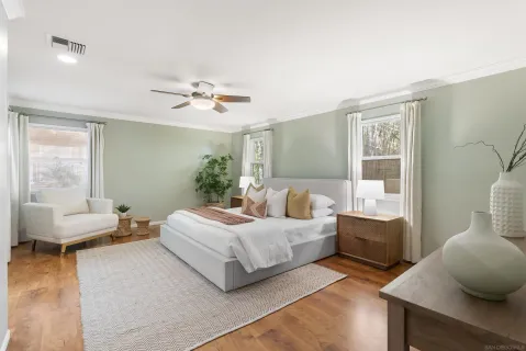 a spacious bedroom with a bed and wooden floor