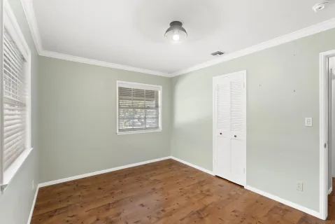 a view of empty room with wooden floor