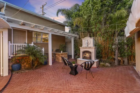 a roof deck with table and chairs and potted plants