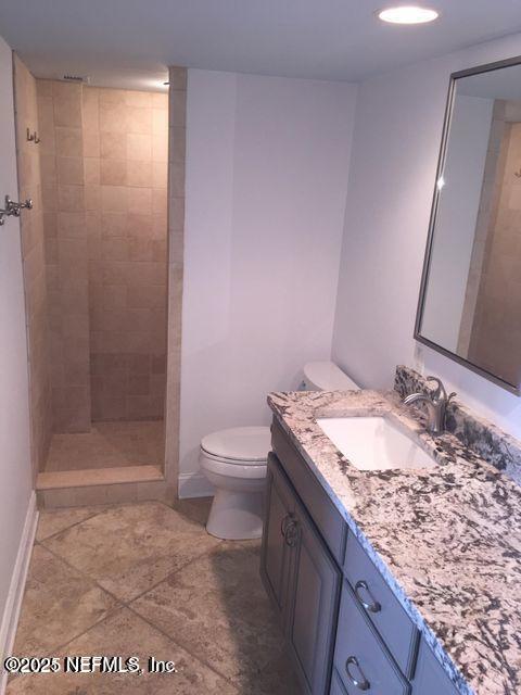 1601 Ocean Drive South, Unit 309 Jacksonville Beach, FL 32250 - Photo 11 of 18 a bathroom with a granite countertop sink a toilet and shower