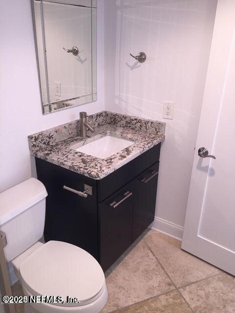 1601 Ocean Drive South, Unit 309 Jacksonville Beach, FL 32250 - Photo 12 of 18 a bathroom with a granite countertop toilet sink and mirror