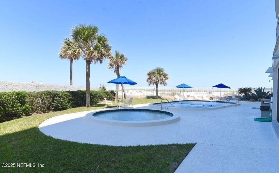 1601 Ocean Drive South, Unit 309 Jacksonville Beach, FL 32250 - Photo 4 of 18 a swimming pool with outdoor seating and yard