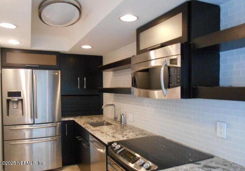 1601 Ocean Drive South, Unit 309 Jacksonville Beach, FL 32250 - Photo 8 of 18 a kitchen with stainless steel appliances granite countertop a refrigerator and a sink