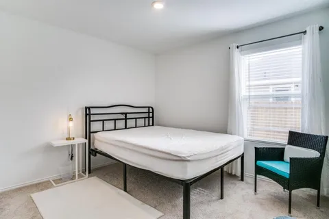 a bedroom with a bed a table and chair