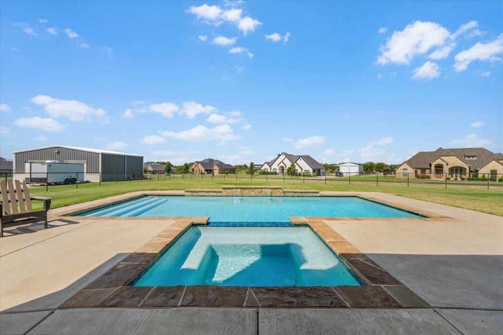 329 Palo Alto Drive Springtown, TX 76082 - Photo 29 of 34 Backyard oasis featuring a rectangular swimming pool with integrated spa, water features and stepped entry
