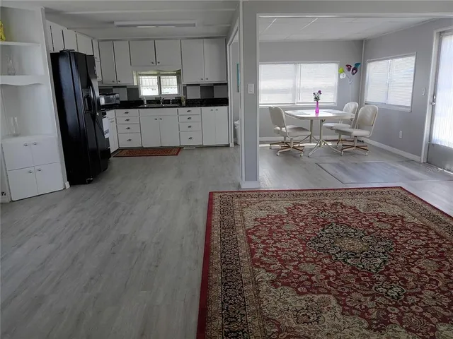 a large kitchen with lots of counter space and wooden floor