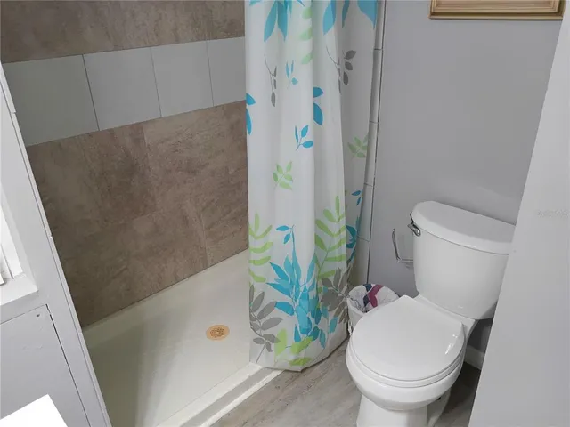 a white toilet sitting next to a bathroom sink and a shower