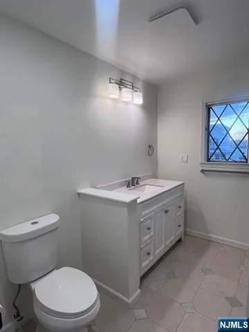 a bathroom with a sink vanity and toilet
