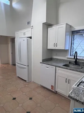 a kitchen with white cabinets and white appliances
